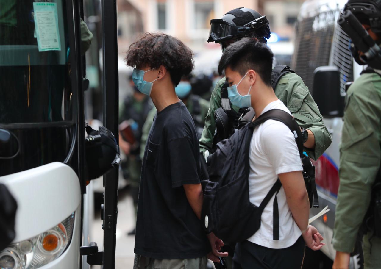 Hong kong police arrest dozens of protesters as government delays elections report